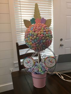 a potted plant filled with lots of candies on top of a wooden table