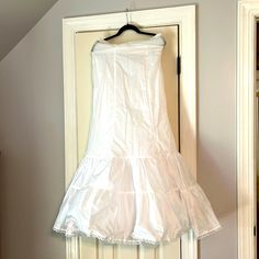 a white dress hanging on a door