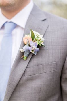 a man in a suit and tie with a boutonniere on his lapel