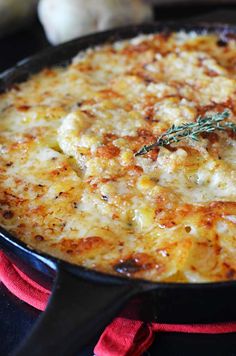 a close up of a pizza in a skillet on a stove with garlic and herbs