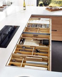 an open drawer with utensils in it