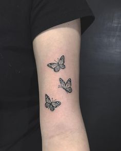 three butterflies tattoo on the left inner arm and wrist, one is black and white