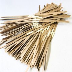 a pile of wooden sticks sitting on top of a white table