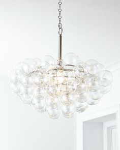 a chandelier hanging from the ceiling in a room with white walls and flooring