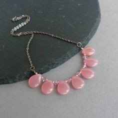 Perfect for adding a pop of colour to your outfit, this dusky pink fan necklace is made using Czech glass teardrops, punctuated with Swarovski crystals. The elegant fan design makes this dusty rose necklace ideal for everyday or an evening out. The translucent teardrops are a pretty shade of pink. Each tear drop necklace measures 17 inches / 43cm in length and is finished with a gunmetal plated lobster clasp and trace chain. Each necklace is fitted with a 2 inch extension chain to allow you to a Chunky Stone Necklace, Jewelry King, Fan Necklace, Fused Glass Necklace, Glass Drop Earrings, Rose Necklace, Pink Necklace, Pink Jewelry, Teardrop Necklace