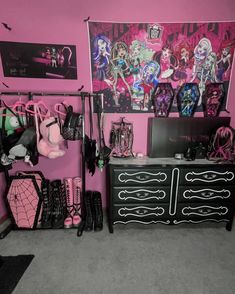 a room with pink walls, black furniture and monster dolls on the wall above it