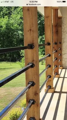 a wooden porch with metal railings on the side and grass in the back ground