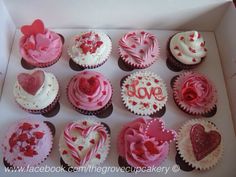 a box filled with lots of cupcakes covered in pink frosting and hearts