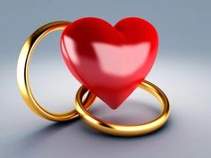 two gold wedding rings with a red heart on the middle and one in the middle