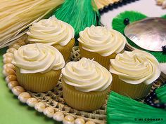 cupcakes with white frosting sitting on a plate