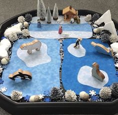 a table that has some fake snow and trees on it with people in the background