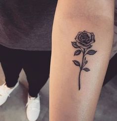 a woman's arm with a rose tattoo on it