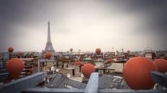 the eiffel tower is in the distance with many balloons floating over it's rooftops