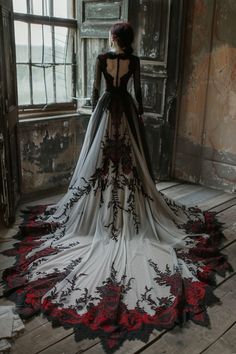 the back of a woman's wedding dress in an old room with large windows