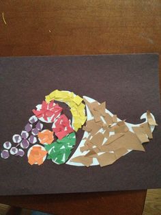 a piece of paper that has been made to look like a turkey with grapes and oranges on it