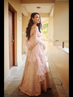 a woman in a pink dress is standing on the floor and looking off to the side