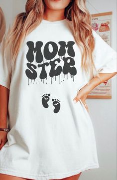 A vintage look graphic shirt that says Momster in a Black Halloween font that looks like it’s dripping or melting. Underneath the momster design are two black baby feet silhouettes with little white bats inside the baby feet on the stomach. Pregnancy Halloween Shirts, Halloween Pregnancy Costumes, Pregnancy Halloween Costumes, Maternity Costumes, Maternity Halloween Costumes, Decoration Ideas For Halloween, Pregnant Halloween Costume, Halloween Maternity Shirt