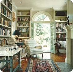 a living room filled with lots of books and furniture