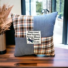 a pillow with a patchwork design on it sitting on a table next to a potted plant