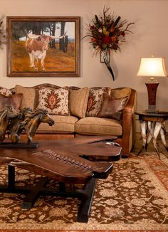 a living room filled with furniture and paintings on the wall above it's coffee table