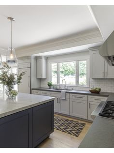 a large kitchen with white cabinets and gray counter tops is featured in this magazine cover