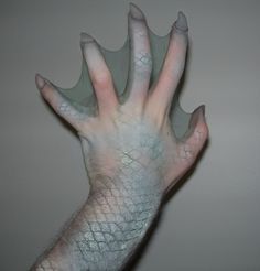 a hand that is holding something in it's right hand and the other hand has an odd pattern on it