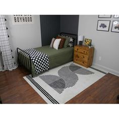 a bedroom with a bed, dresser and rug