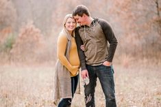 a man and woman standing next to each other in a field