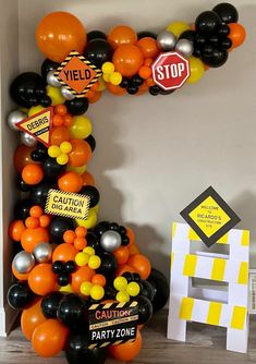 the letter c made out of balloons is decorated with black, orange and yellow colors