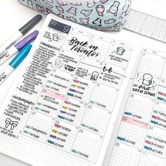 an open planner with stickers on it next to some pens and a pencil holder