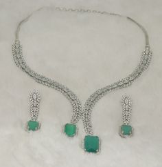 Faux CZ Diamonds Mint Emerald Necklace Earrings Set, Bridal Dangler Earrings, Bridal Choker, Party Wear Necklace Earrings, Statement Piece ITEM DESCRIPTION Metal        = Silver Plated Occasion  = Wedding, Party Wear, Bridal Color        = White and Green Size          = Necklace Length = 7 Inches Long, Earring Size = 22 Inches Long,  Free Shipping 100% Satisfaction Guarantee: 1 Year Warranty, Long Lasting Plating, High-Quality Stones Occasion: Perfect choice for any Indian occasion.  Care: It is advisable that you keep products away from direct heat, humidity, and moisture. It is best to preserve your jewelry in the box. Keep Away From Water, Spray And Perfumes For Better Look. Happy Buying :) Cubic Zirconia Dangle Bridal Necklace For Party, Hand Set Green Jewelry For Party, Party Jewelry Sets With Matching Dangle Earrings, Party Dangle Necklaces With Matching Earrings, Silver Bridal Necklace With Matching Earrings For Party, Long Earring, Bridal Choker, Dangler Earrings, Wear Necklaces