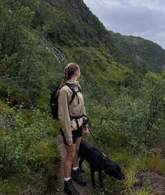 a woman hiking with her dog on a trail