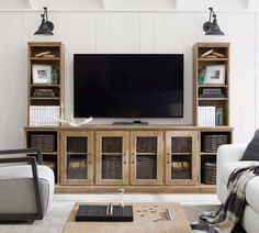 a living room filled with furniture and a flat screen tv on top of a wooden entertainment center