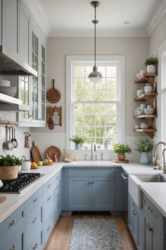 a kitchen with blue cabinets and white counter tops, wooden flooring and open shelves