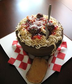 there is a cake that looks like it has spaghetti and meat in it on the table