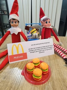 two elfs sitting at a table with macaroni and cheese sandwiches on the plate