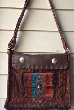 Handwoven Leather Bag/Purse with Hard leather at the sides and bottom. This bag is woven with a deep rust/red 100%wool yarn with turquoise accents in the design. The top of the bag closes with a hand stitched leather flap with two nickel silver flower stamped buttons and snap closures.  There is an enclosed woven pocket in the front and the bag is fully lined with a soft velvety suede and and two inner pockets with button enclosures inside.  Leather is all hand stitched. The adjustable shoulder Brown Hand-stitched Tote Shoulder Bag, Brown Hand-stitched Crossbody Bag, Brown Handwoven Satchel For Everyday Use, Brown Handwoven Satchel For Everyday, Hand-stitched Brown Shoulder Bag For Travel, Red Rectangular Shoulder Bag With Leather Trim, Brown Hand-stitched Shoulder Bag For Travel, Everyday Brown Handwoven Satchel, Handwoven Leather Crossbody Satchel