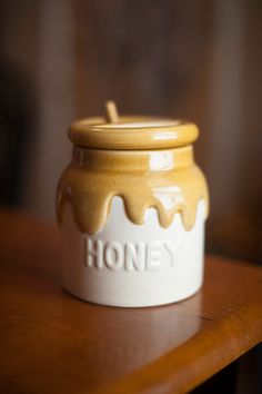 a honey jar sitting on top of a wooden table