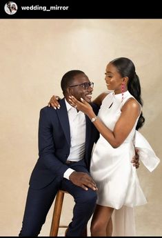 a man and woman sitting next to each other in front of a white wall with the words wedding mirror written on it