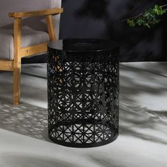 a black table sitting next to a chair on top of a white carpeted floor