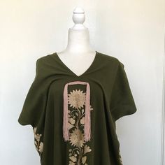 This hand-woven two panel Mexican Yalalag Hupil long tunic is a VINTAGE CLASSIC with flowers embroidered by hand by artisans of Oaxaca 100% handmade. A relaxed style and at the same time looks very elegant for a party in the morning or afternoon. It is made of 100% cotton blanket fabric. MADE IN MEXICOBy: Mexican ArtisansFor: Women Size: M/L Color: khaki green | gold Length: 41.5" Details: Material: cotton silk Non-stretch Embroidered thread Front & back tassels Ankle Length Washing Instructions Folk Style Poncho With Floral Embroidery, Bohemian Embroidered Summer Poncho, Embroidered Bohemian Poncho For Summer, Traditional Tunic For Spring, Traditional Free Size Tunic For Spring, Blanket Fabric, Flowers Embroidered, Cotton Blanket, Long Tunic