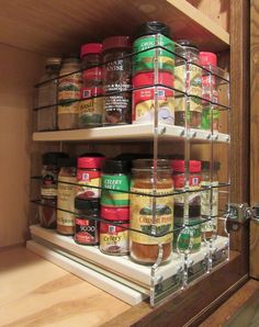 an organized spice rack in a kitchen cupboard