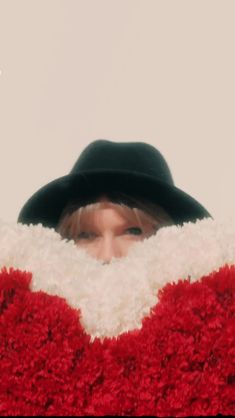 a woman wearing a red and white sweater with a black hat on top of her head