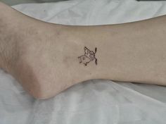 a person's foot with a small tattoo on the left side of their leg