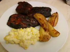 a white plate topped with meat and potatoes