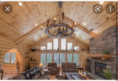 a living room filled with furniture and a chandelier hanging from the ceiling over a fire place