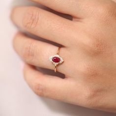 a woman's hand with a diamond and ruby ring