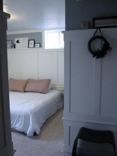 a white bed sitting next to a doorway in a bedroom on top of a carpeted floor