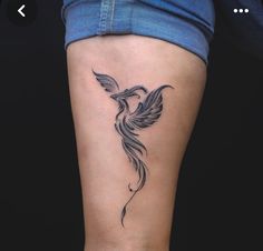 a woman's thigh with a bird tattoo on the side of her leg that is black and grey