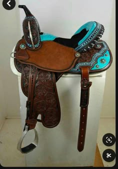 a brown and blue horse saddle sitting on top of a white box